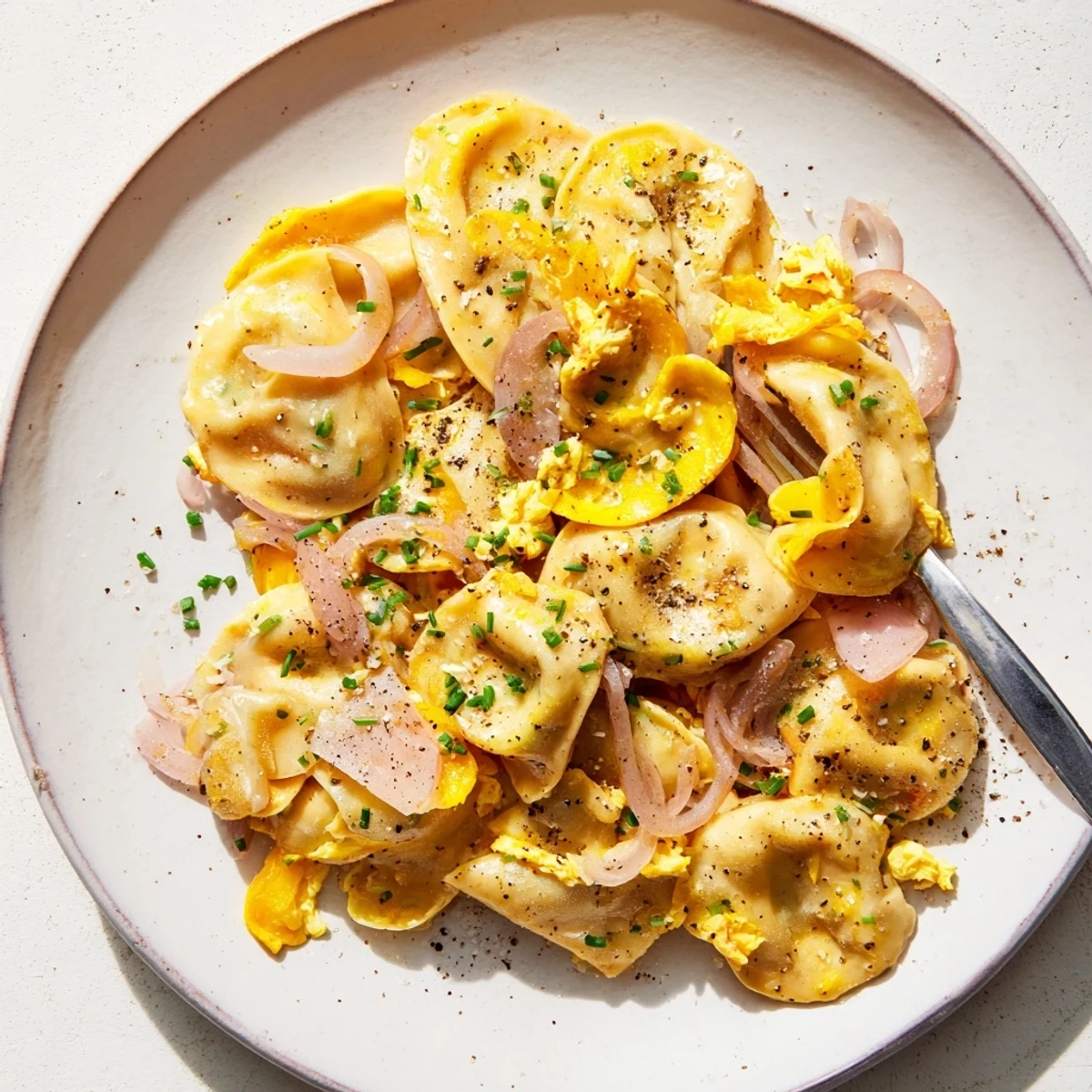 Würzige Swabian Maultaschen-Pfanne, serviert mit weich gerührten Eiern und Chias.  