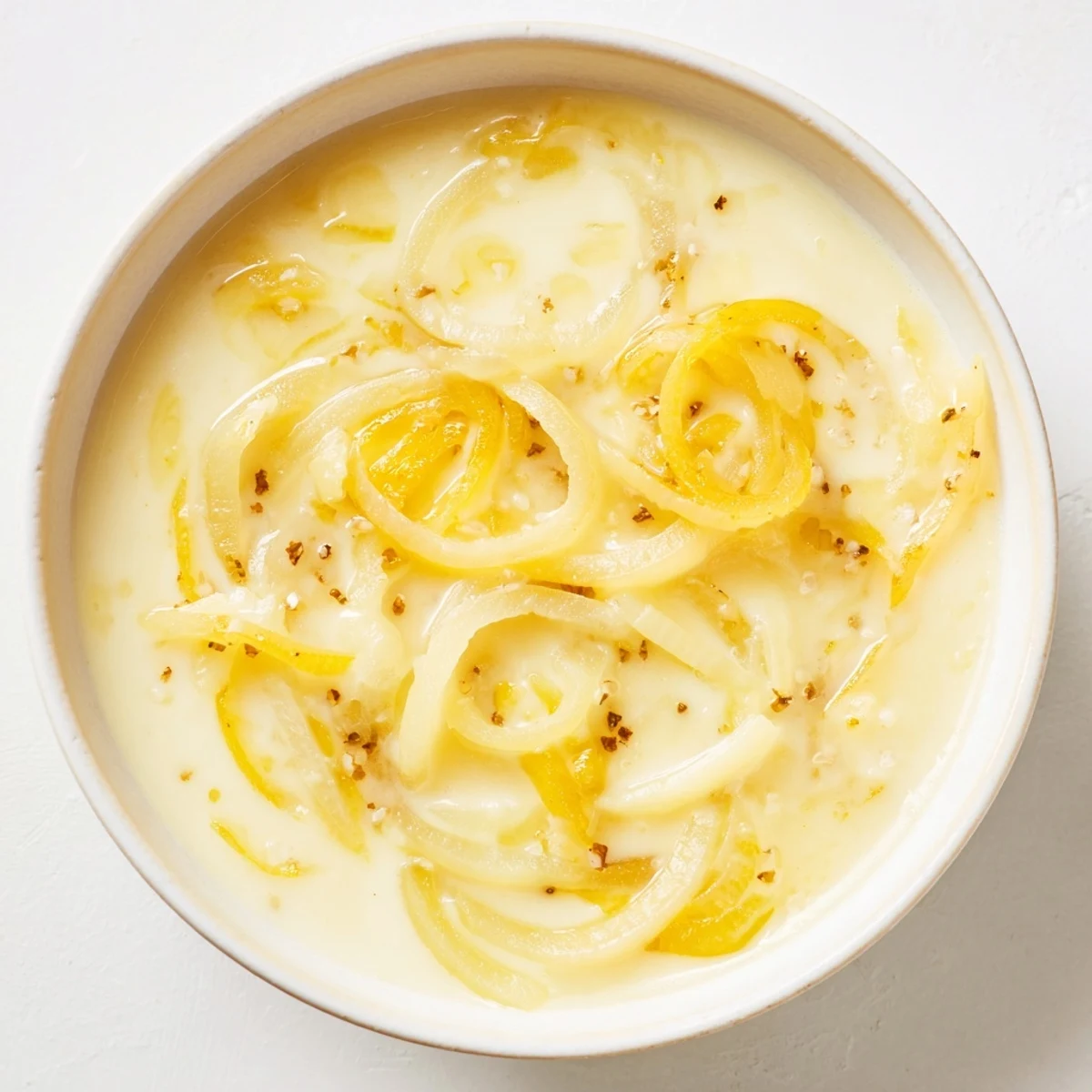 Close-up of a steaming bowl of German Cheese and Onion Beer Soup; a comforting vegetarian meal.