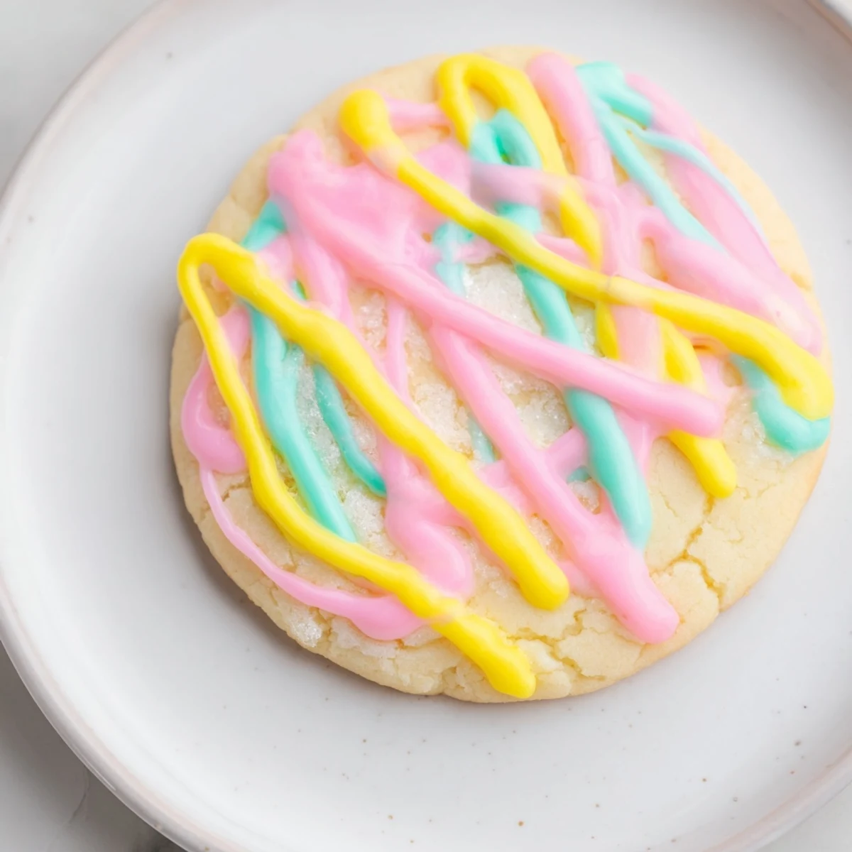 Freshly baked sugar cookies, beautifully drizzled with vanilla icing, ready to eat.