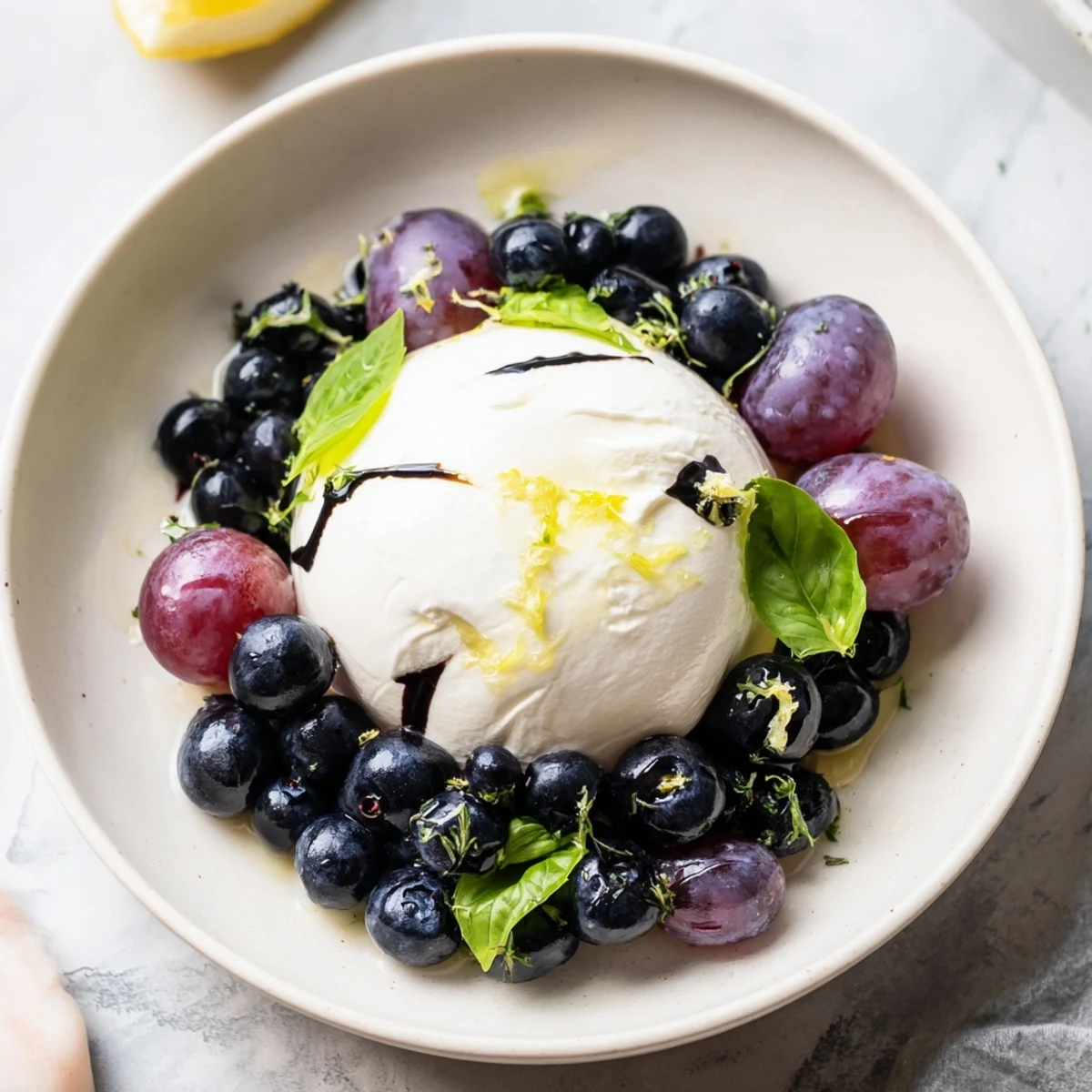 See the Moonlit Lagoon salad, grapes and burrata, drizzled with balsamic glaze, ready to enjoy.