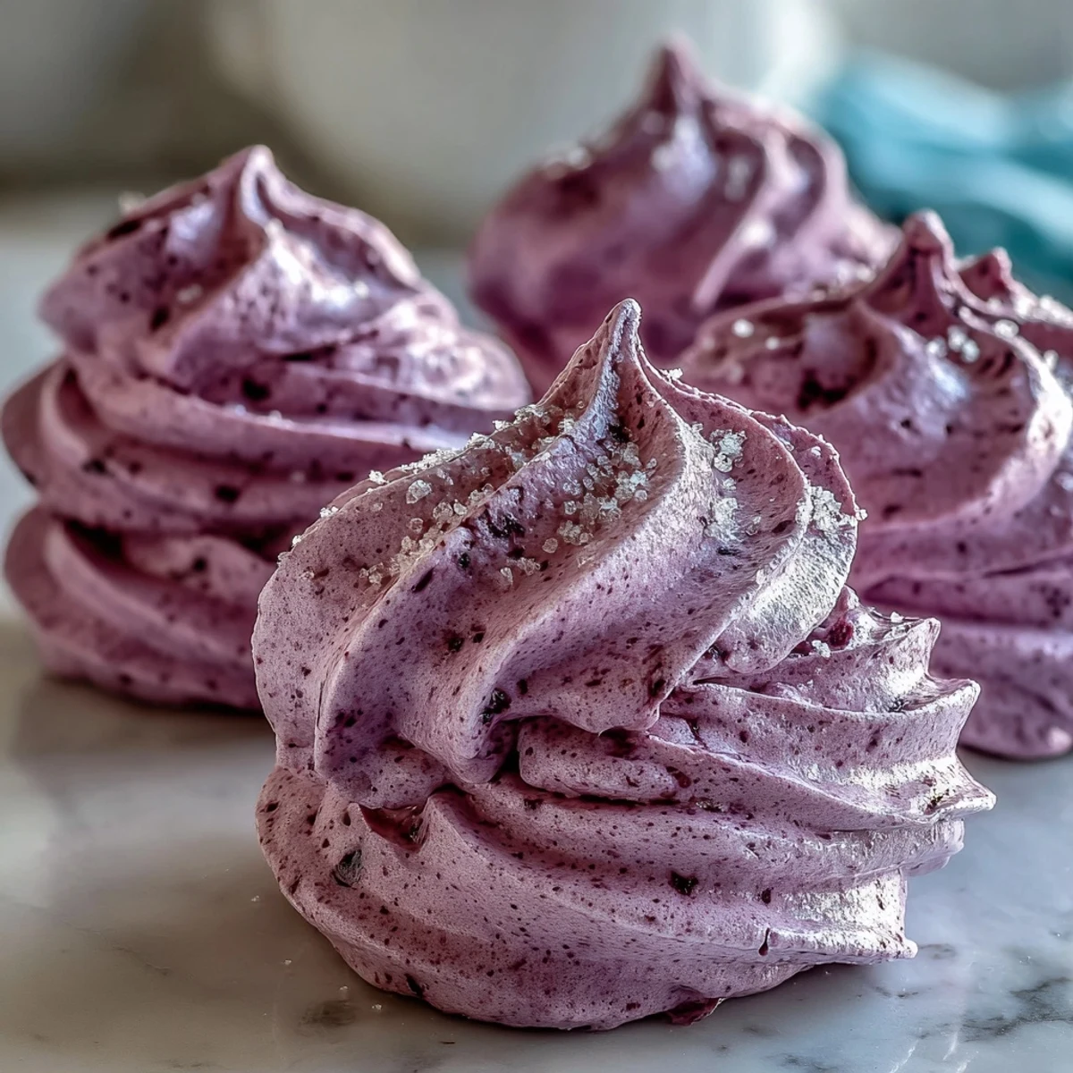 Delikate, knusprige Black Currant Meringues mit leuchtendem schwarzer Johannisbeere-Twist, serviert auf einem eleganten Tablett.