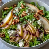 Ein leuchtend grüner Salat mit süßen Birnen und würziger Vinaigrette für gesunde Mahlzeiten.