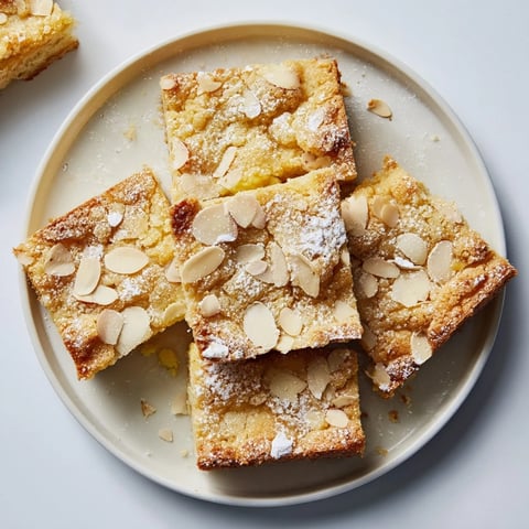 Golden-brown German butter cake slice, topped with almonds and sugar, ready to serve.