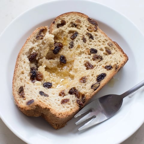 Freshly baked Old-Fashioned German Raisin Bread, golden-brown and ready to slice for breakfast.