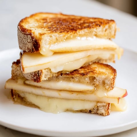 Golden, melted Brie and apple grilled cheese, a warm, comforting sandwich ready to eat.