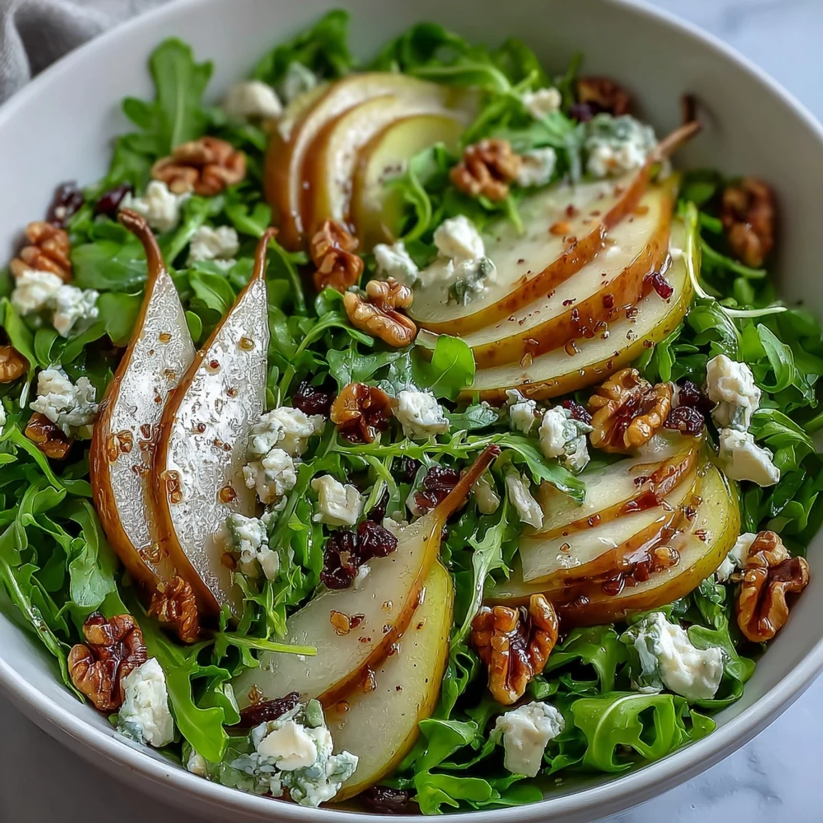 Frische Arugula und Birne Schüssel mit cremigem Käse und knusprigen Nüssen.
