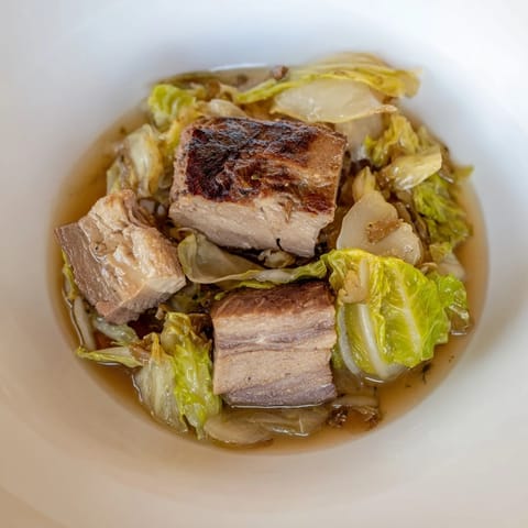 Sizzling close-up of Sweet Cabbage and Pork Stew, ready to serve with crusty bread.