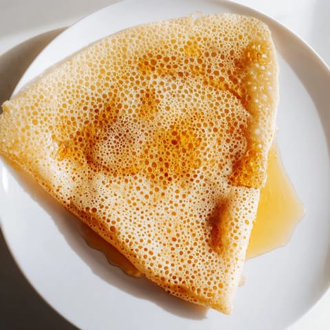 Golden, spongy Moroccan Baghrir crepes served warm with drizzled honey and melted butter.