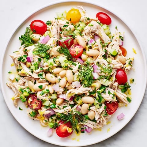 Lemony White Bean Chicken Salad mit saftigem Hähnchen und cremigen weißen Bohnen auf einer frischen Bett aus glasigem Rucola.