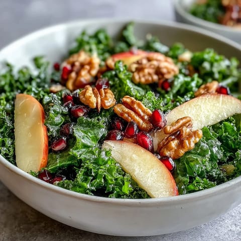 Healthy Kale and Pomegranate Bowl with crunchy walnuts, sweet apple slices, and bright pomegranate seeds.  