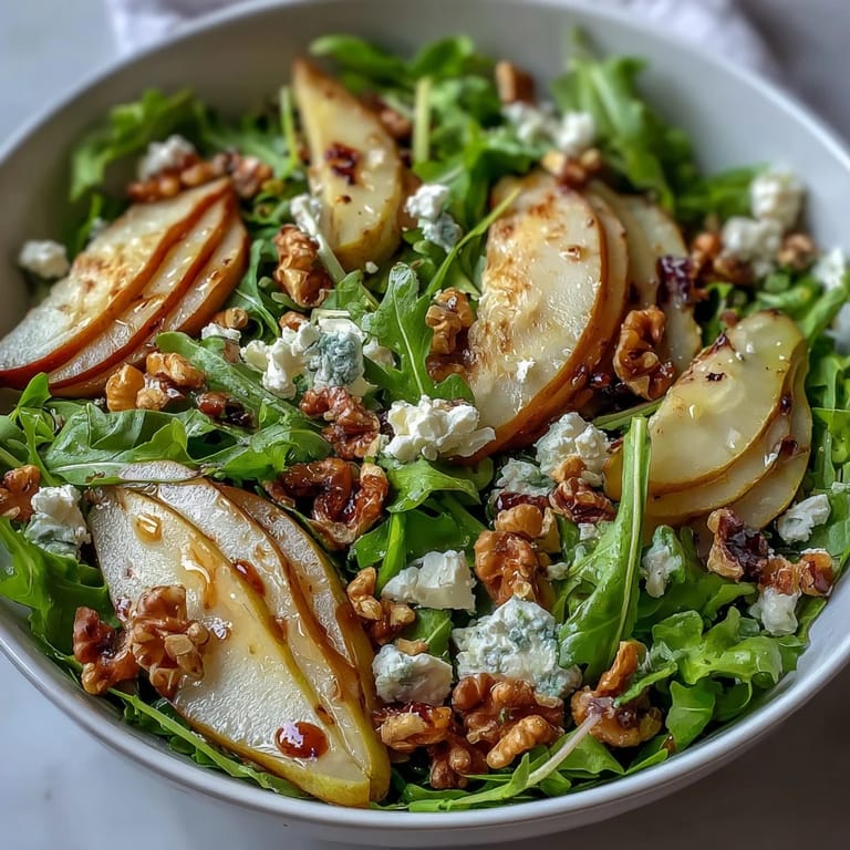 Geröstete Walnüsse und Birnenscheiben auf pepprigem Rucola servieren als leichtes vegetarisches Hauptgericht.