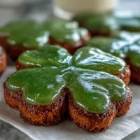Festliche, buttrige Zuckerkekse in Kleeblattform mit leuchtend grüner Royal Icing—perfekt für St. Patrick's Day mit einer süßen, farbenfrohen Note.